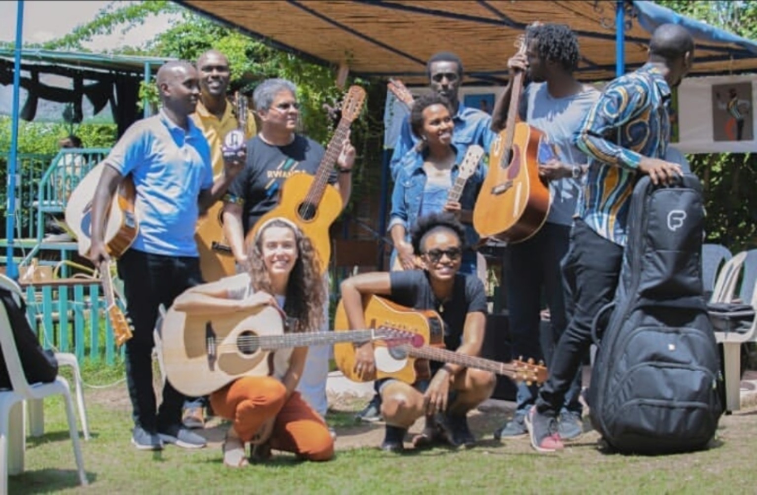 Group of guitarists with instruments gathered outdoors