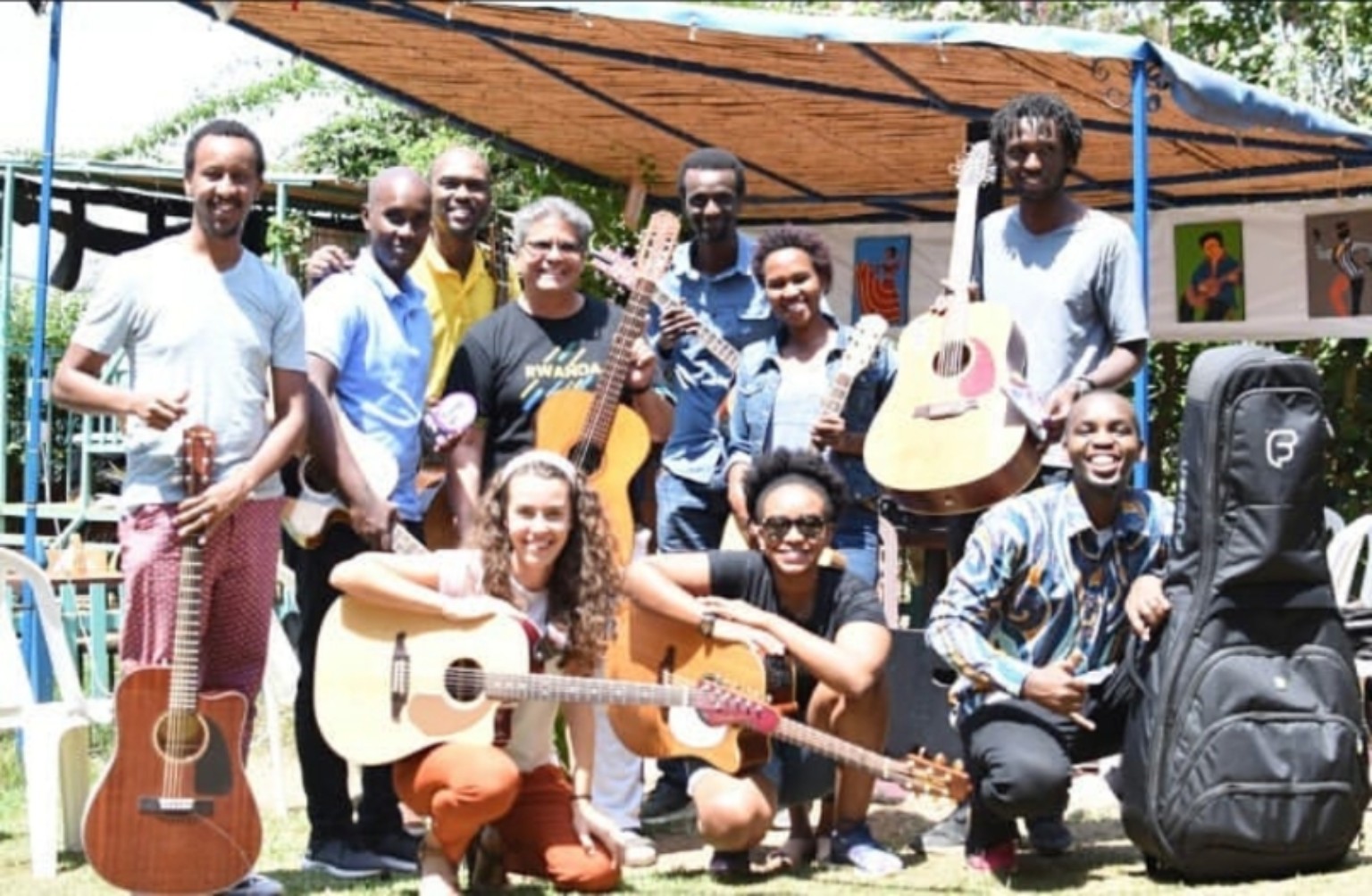 A larger outdoor gathering of guitarists with instruments