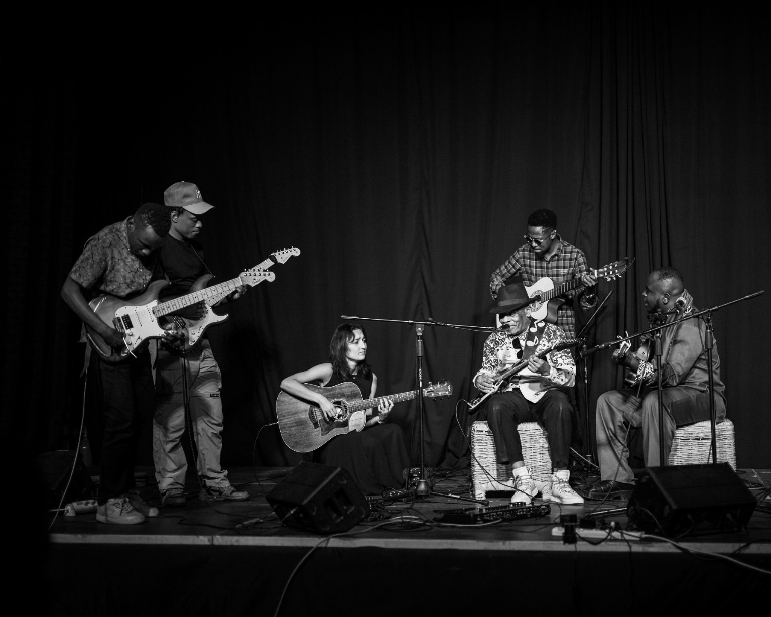 Guitarists performing on stage in black and white